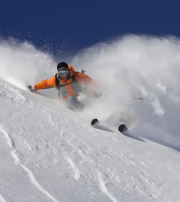 professional skiing going fast turning kicking up snow