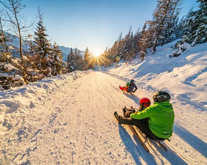 A father and small child sharing a sledge on the Wildkogel toboggan run