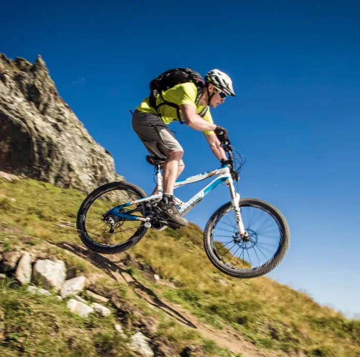Mountain biker on a singletrack trail above the village